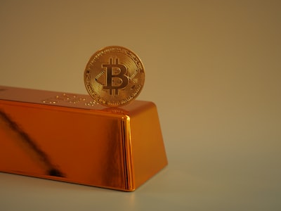 Bitcoin coin resting on gold bar representing digital asset value