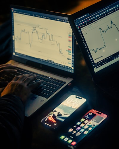 Trader analyzing financial data on laptop with stock charts