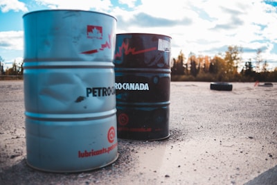 Petroleum storage barrels under cloudy sky representing crude oil supply and the oil price drop below 100 dollars
